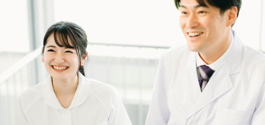 笑顔で会話する白衣の男女