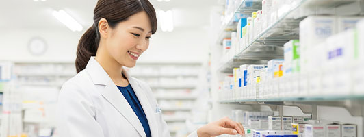 薬剤師が薬局の棚で薬を選ぶ様子
