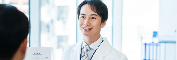 カウンターで薬を渡す男性薬剤師