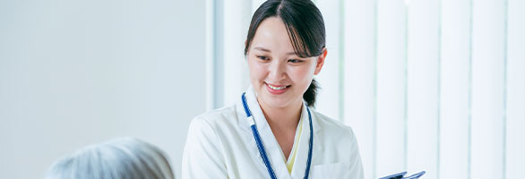 笑顔でメモを取る女性医療従事者