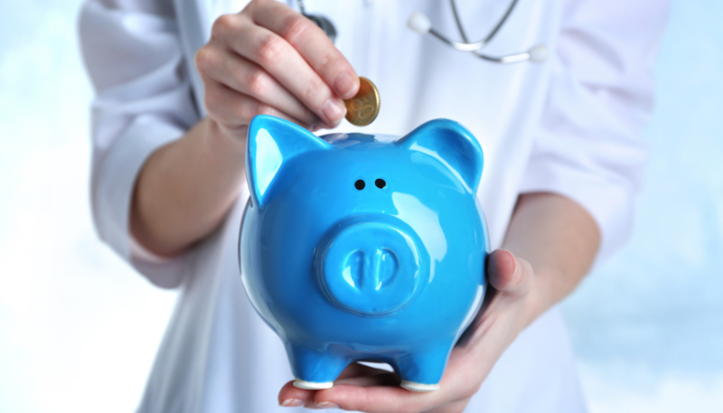 貯金箱にお金を入れる薬剤師の様子