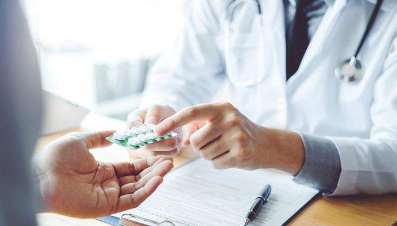 薬を手渡す薬剤師と患者