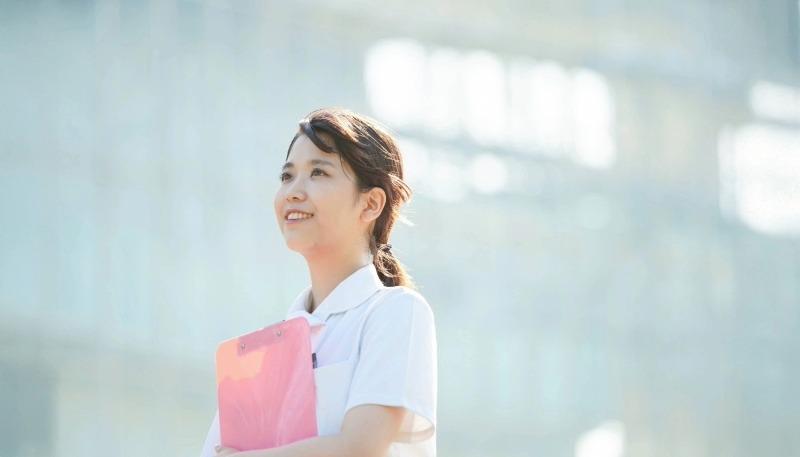 女性が明るい笑顔で明日の方向を見ている写真