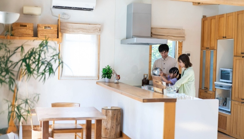 大きな家のキッチンで一緒に料理をする家族の写真