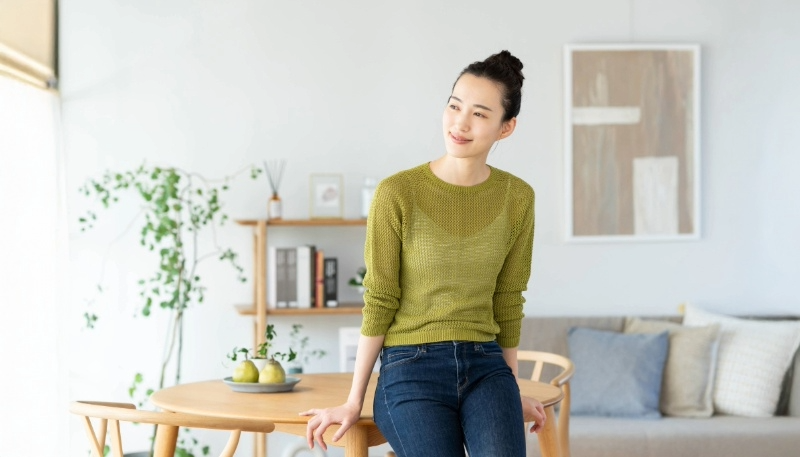 窓の外を見てほほ笑む女性の写真