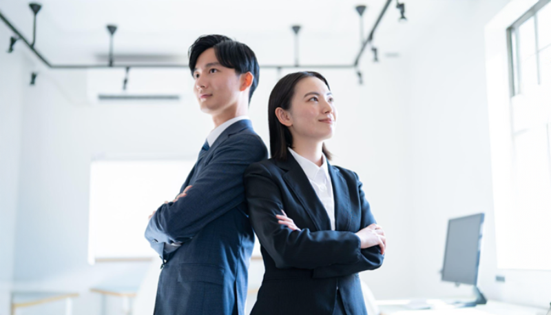 腕を組み上を見る男女
