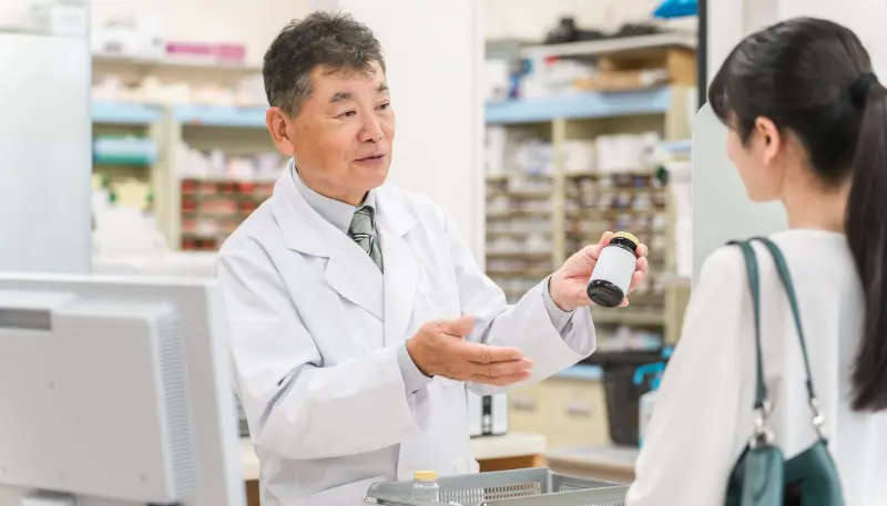 調剤薬局で接客をする薬剤師の男性