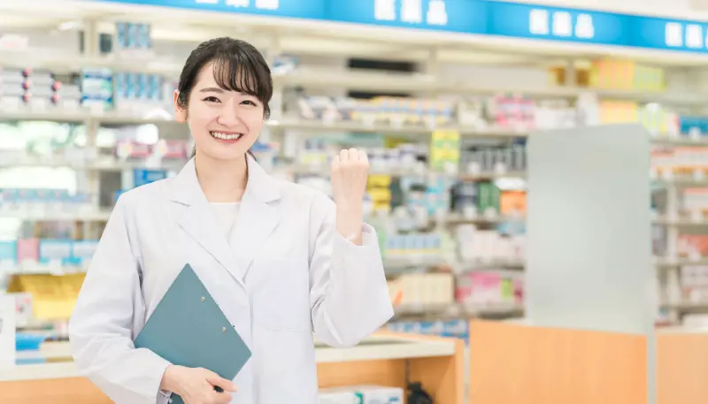 ドラッグストア薬剤師が正面を向いてエールを送る写真
