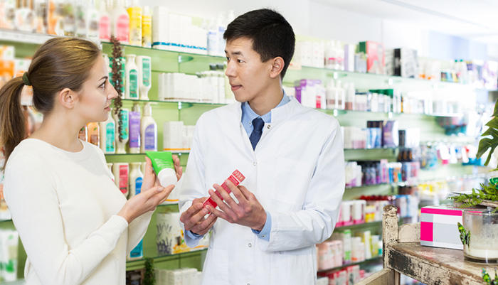 海外の薬局で商品説明をする薬剤師のイメージ