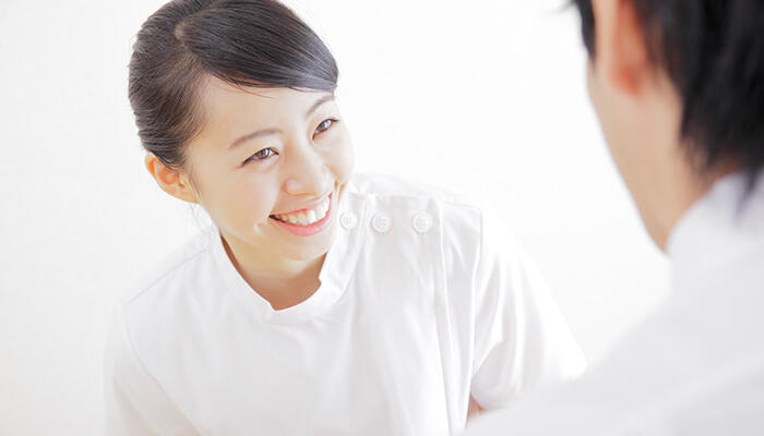 患者と笑顔で会話する薬剤師のイメージ